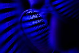 Binary code displayed on a screen reflected in glasses. (Jakub Porzycki/NurPhoto via Getty Images)